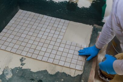Troweling mortar a concrete floor in preparation for laying floor tile. Troweling mortar a concrete floor in preparation for laying floor ceramic tiles