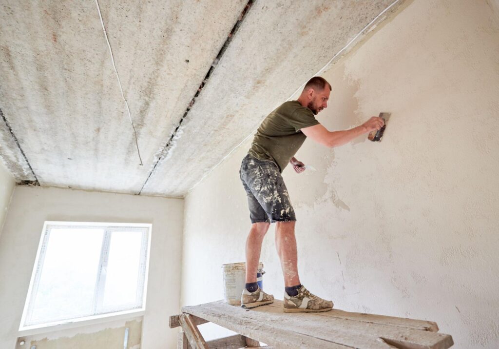 How to Plaster a Wall: A Full Guide 5 Man is plastering a wall