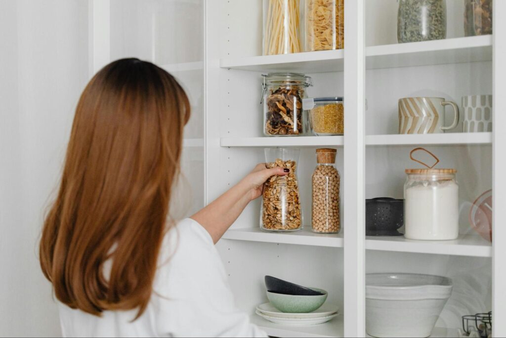 10 Simple and Effective Under Stairs Storage Ideas 6 A woman putting away food in a pantry