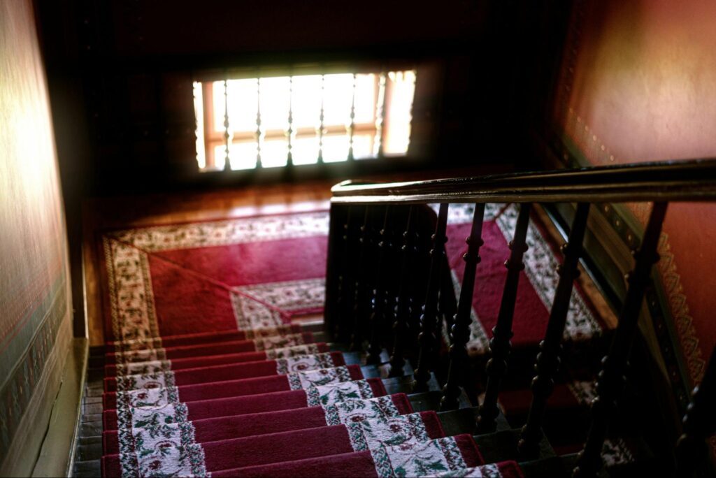 10 Stylish Stair Carpet Ideas 3 A wooden staircase with red rug on it