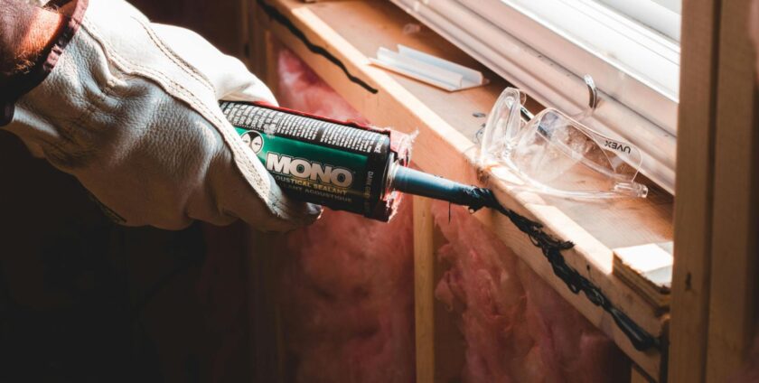 Person gluing plasterboard over insulation material