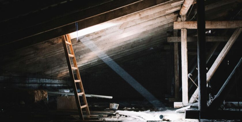 A dark and moody attic with a ray of light coming from a window