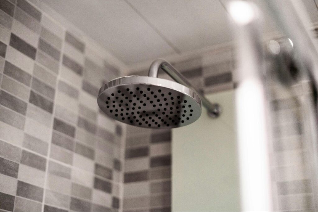 Electric Shower Not Working? Here's Why and How to Fix It 3 A big shower head in a black and white bathroom
