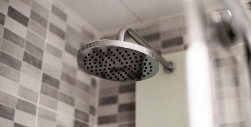 A big shower head in a black and white bathroom
